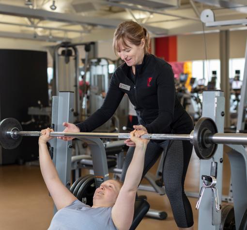 Personal Training YMCA trainer spotting someone using the bench press