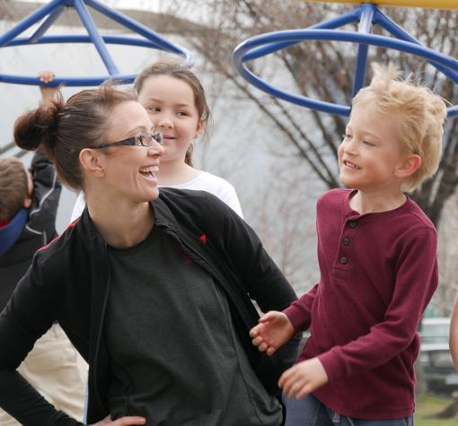 Queen's Park staff and kids (teaser) Staff and children laughing in playground at Queen's Park YMCA Child Care