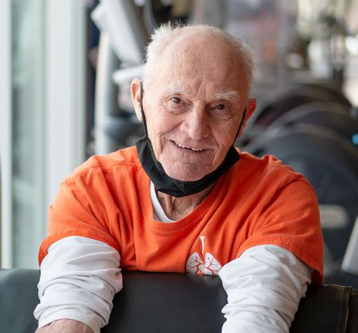 smiling Breathe Well participant using bicep curl machine