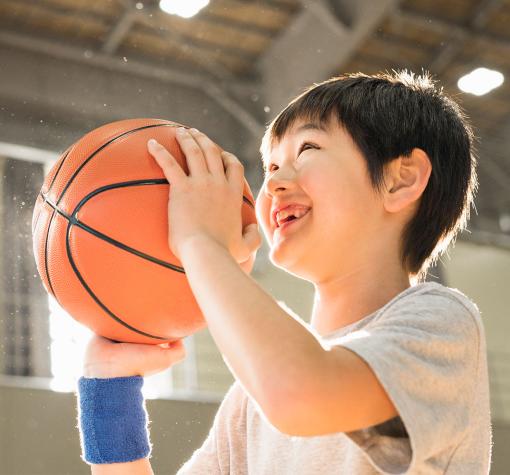 smiling boy preparing to shoot a basketball in the gymnasium