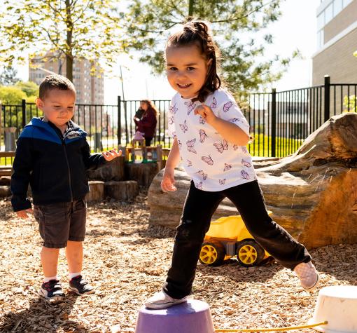 girl and boy playing in natural outdoor playground